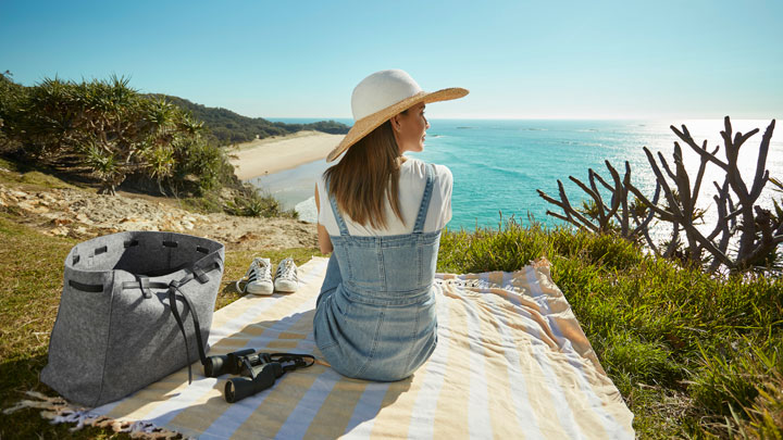 Girl having a picnic overlooking the ocean